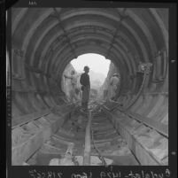Engineer inspecting 1.3-mile long tunnel of water pipeline for Simi Valley, Calif., 1963
