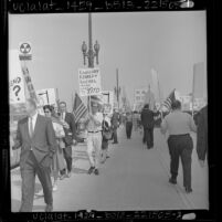 Placard carrying demonstrators parade in front of Los Angeles' Federal Building in protest over Yugoslavia's President Tito visit, 1963