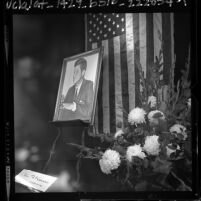 Store window display in memorial of John F. Kennedy, American flag and flowers, 1963