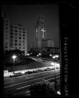 Night scene of Los Angeles City Hall with windows lit to form a cross in memorial to John F. Kennedy, Calif., 1963