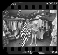 Comedian Phyllis Diller surveying her wardrobe in her 18x30-foot closet, Calif., 1978