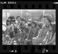 School principal Julia M. Tyler sitting with diverse group of students brought in during school integration in Los Angeles, Calif., 1980