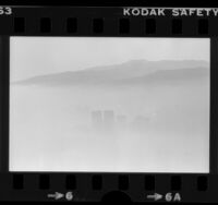 Century City towers peeking through smog with Santa Monica Mountains in background, Calif., 1980