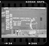 Advertisement for herbs and acupuncture written in English and Korean on side of building in Los Angeles, Calif., 1982