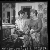 Alhambra councilwoman, Norma Yocum cooking at stove with daughter Phyllis, 1963