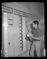 Student Bob Glassman selecting items from one of 22 food vending machines at Santa Ana High School, Calif., 1964