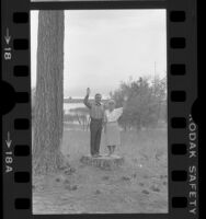 Presidential candidate Walter Mondale and Geraldine Ferraro posing on a stump near Lake Tahoe, Calif., 1984