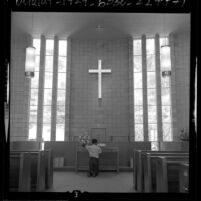Boy kneeling at altar in chapel at the LeRoy Boys Home in La Verne, Calif., 1964