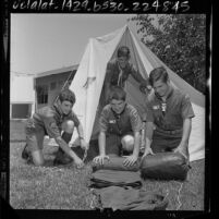 Four Boy Scouts rolling up sleeping bags before leaving to National Jamboree at Valley Forge, Penn., 1964