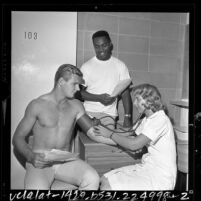 Los Angeles Ram's Mel Profit with Willie Brown having blood pressure taken by nurse at training camp, Calif., 1964