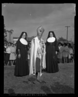 Reverend Timothy Manning, flanked by two nuns, at ground breaking for downtown campus of Mount St. Mary's College in Los Angeles, Calif., 1965