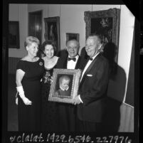 USC President, Dr. Norman Topping, Catherine Graw with Armand and Francis Hammer holding painting Hammer donated to USC, 1965