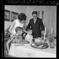 Bennett family gathered around Seder table upon which sits symbolic Jewish foods in Beverly Hills, Calif., 1965