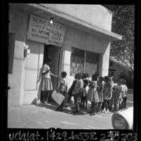 Teacher's aide greeting African American students at the door of a church converted into a "Freedom School" in San Bernardino, Calif.