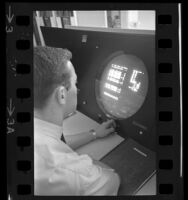 Man working at computer with round monitor screen, 1965