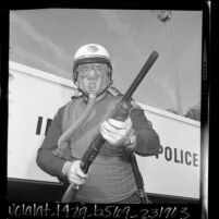 Special Forces Detail policeman C.J. O'Connell wearing gas mask, bullet-proof vest holding shot-gun, Inglewood, Calif., 1966
