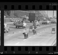 California highway crew placing "Botts' Dots" (lane lines) on lanes of Hollywood Freeway, Los Angeles, 1966