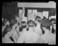 Los Angeles Pacific Electric employees reading bulletin setting forth cancellation of strike order, 1943
