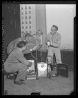 Dr. George M. Uhl, city health officer demonstrating electrostatic precipitator, or "smog catcher" in Los Angeles, Calif., 1945