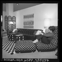 Caryn Leff relaxing in MOD style living room at the Los Angeles Home Furnishing Mart, 1967