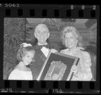 Aaron and Tori Spelling with Les Dames de Champagne president, Toni Webb posing with Host of Year award in Los Angeles, Calif., 1985