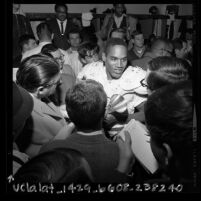 O.J. Simpson talking to reporters in locker-room after USC football game, 1967