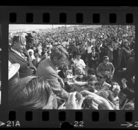 Robert F. Kennedy, in front of crowd, shaking hands with students of the Bolsa Grande High School in Garden Grove, Calif., 1968