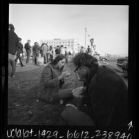 Group of Hippies receiving free food at beach front parking in Venice, Calif., 1968