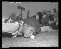 Henry Ross tries rolling an egg with his nose in the Elks' egg-rolling contest in Los Angeles, Calif., 1949