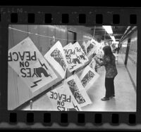 UC Berkeley student hanging anti-war posters up to dry on a moving clothesline in Wurster Hall, 1970