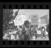 Jonathan Peter Jackson (face obscured by sign) walking with Angela Davis at march for the Soledad Brothers in Los Angeles, Calif., 1970