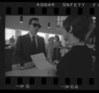 Beverly Hills police officer posing as a bank robber for a bank employee training program, 1970