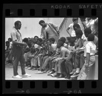 Football player Ollie Matson talking with group of boys at John Muir Junior High in Pasadena, Calif., 1970