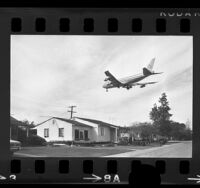 Airplane passing over a house being moved near Los Angeles International Airport, 1970