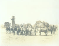 Cowboys on horseback gathered near watertower at Universal City, Calif., circa 1915