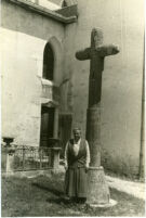 Gertrude Stein standing before cross in churchyard, 1934