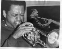 Bobby Bradford, portrait with photograph of John Coltrane in background [descriptive]