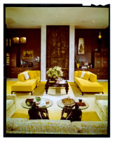 living room with yellow couches and elephant end tables
