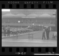 Police and civilians await the arrival of President Johnson at the Pavillion Shops in Century City, 1967.