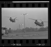 Helicopters land next to a fire engine in a parking lot near Century Plaza during President Johnson's visit, 1967.