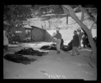 Police outside of the ruins of Fountain of the World headquarters look at bodies of the victims of the bombing. C. 1958.