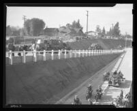 Military trucks on off-ramp as motorcycles pass on Arroyo Seco Parkway at dedication, Los Angeles, 1940