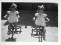 Two little girls on tricycles