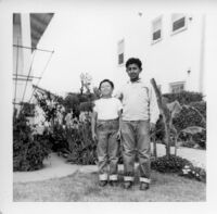 Two boys standing in front of garden