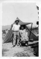 Man and Woman standing in front of tent