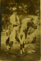 Boy dressed as cowboy on fake horse
