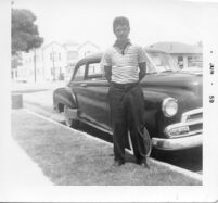 Man posing in front of car