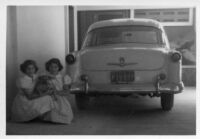 The Guardia daughters sitting by car