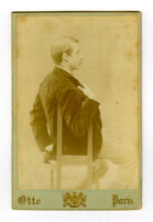 Robertson, W. G. sitting in chair, holding lapel.