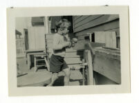 Child sawing a board, 1932-1933.
